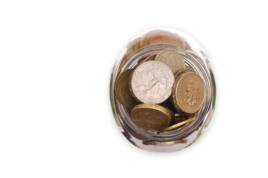 Transparent glass jar with coins isolated on a white background, top view