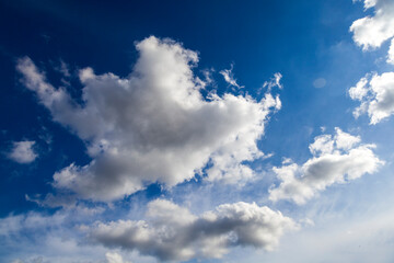 Naklejka na ściany i meble Curly, fleecy beautiful clouds on a blue sky,