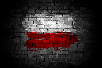 Poland flag painted on a grey brick wall in an urban location