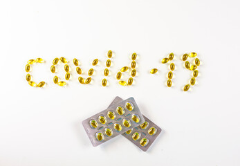 covid -19 laid out in the form of capsules with vitamin D with packaging of tablets in a blister on a white background