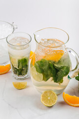 Orange and lime lemonade in a jug and glass