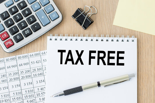 TAX FREE inscription in a white notebook on the table next to a calculator, pen, numbers on a sheet of paper. Tax concept