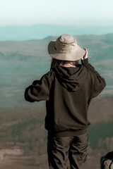 Girl Hiker on the top of the mountain looking at the view