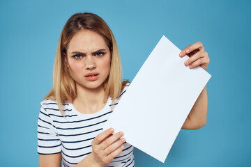 Naklejka premium Emotional woman holding a sheet of paper in her hands lifestyle close-up blue background Copy Space