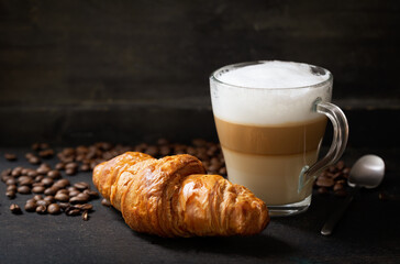 glass of latte macchiato coffee and croissant