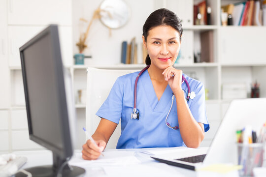 Kazhahstani Female Doctor In Uniform Is Working Behind Laptop In Hospital