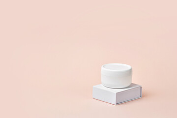 Blank white plastic container for cream, lotion, nourishing or moisturizing mask on stand. Feminine hygienic product.