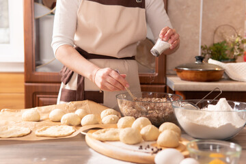 A woman in the kitchen prepares pies for her family.