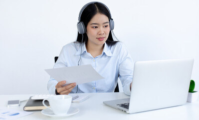 Young white Asian woman studying via the internet in her home office.