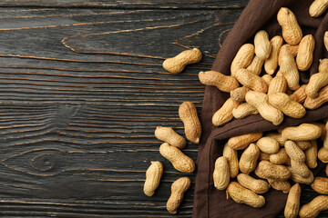 Napkin with peanut on wooden background, top view