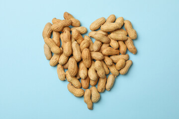 Heart made of peanut on blue background