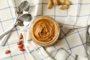 Napkin with peanut, jar of peanut butter and spoons