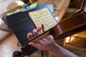 close up of hands playing violin