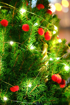 Handmade small red balls from paralon as decoration for New Years celebration, close-up. Winter christmas tree in the snow with bauble