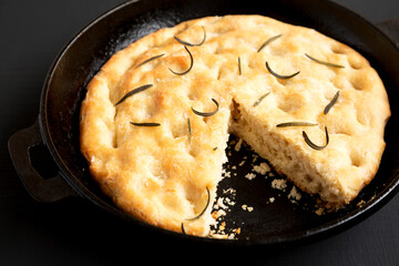 Homemade Rosemary Skillet Focaccia on a black background, low angle view. Close-up.