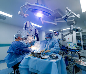 Neurosurgeon is operating with medical robotic surgery machine. Manual control by minimally...