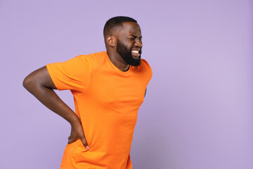 Sick tired young african american man wearing basic casual empty blank orange t-shirt feels bad...