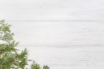Photo of thuja Christmas tree branches on white wooden background with copy space