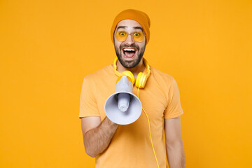 Excited surprised shocked young bearded man 20s wearing basic casual t-shirt headphones eyeglasses...