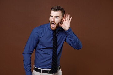 Shocked curious young business man in blue shirt tie try to hear you overhear listening intently...