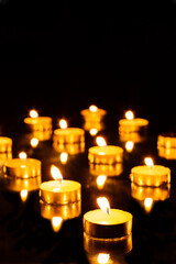 Tea candles burning in the dark