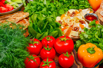 Presentation of variety georgian cuisine - tomatoes, lavash bread, pickles, spinach, lettuce, bryndza, suluguni cheeses.