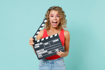 Excited surprised young blonde woman 20s wearing pink basic casual tank top hold classic black film...