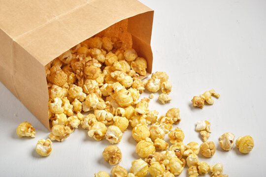 caramel popcorn in paper bag on grey background no label package - Powered by Adobe