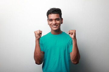 Fototapeta premium Happy young man of Indian origin with a cheering gesture