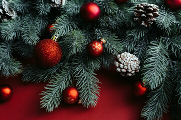 Christmas red decorations, fir tree branches on red background. Flat lay. Nature Christmas concept. Flat lay, top view, copy space