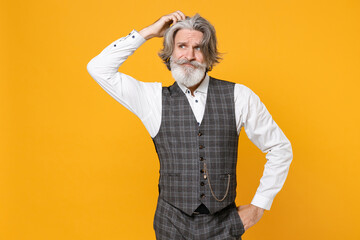 Preoccupied elderly gray-haired mustache bearded business man in checkered suit waistcoat white shirt put hand on head isolated on yellow background studio portrait. Achievement career wealth concept.