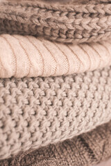 Set of cozy knitted sweaters in stack close up. Winter season.