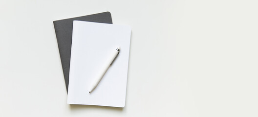workspace with white and gray notepad. two notepads lie on a plain background with a pen. business concept for meeting