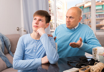 Portrait of angry father quarreling with his teenage son