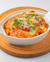 Italian lasagna served in a white pot over white background. Delicioud dinner concept, Italian cuisine.