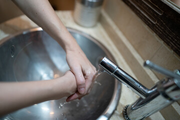 Mujer se lava las manos en el baño. Medidas para prevenir covid19