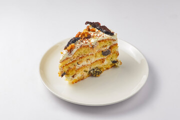 One piece of Prune honey cake served on a white plate over white background. Isolated on white.