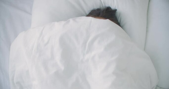 woman Peeking under duvet and smiling. Smiling cheerful woman peeking out from under the blanket in bed at home and kissing camera