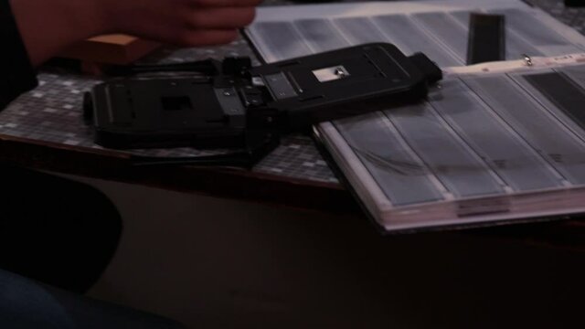 Young photographer&nbsp;placing the negative in the enlarger carrier.