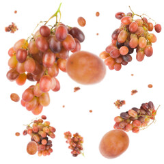 Fototapeta na wymiar Many red/orange grapes free falling on white background. Selective focus - shallow depth of field.