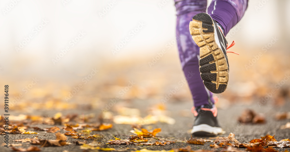 Wall mural close-up view of female legs and shoes running in autumn nature