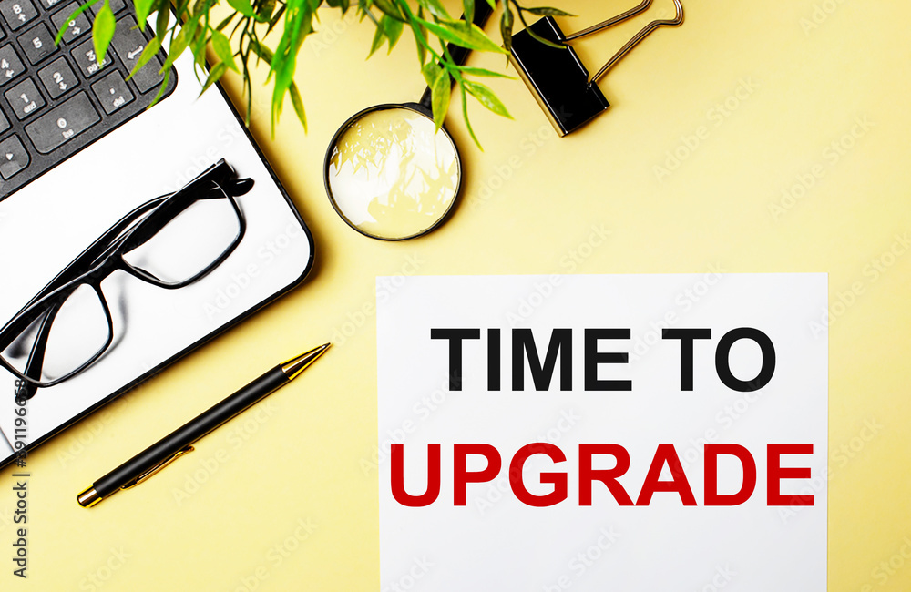 Poster time to upgrade is written in red on a white piece of paper on a light yellow background next to a l