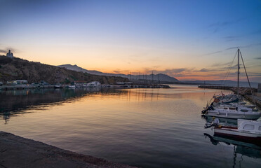 Fototapeta premium view of small fishing harbour in Rafina city at sunset .Greece