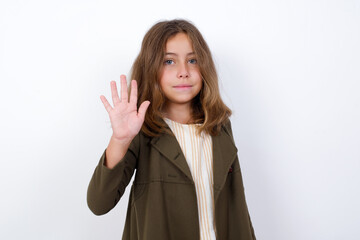 Beautiful little girl standing against white background,  showing and pointing up with fingers number five while smiling confident and happy.