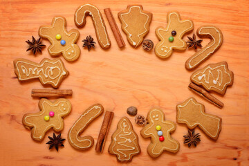 Festive background with gingerbread cookies and spices arranged on a wooden board