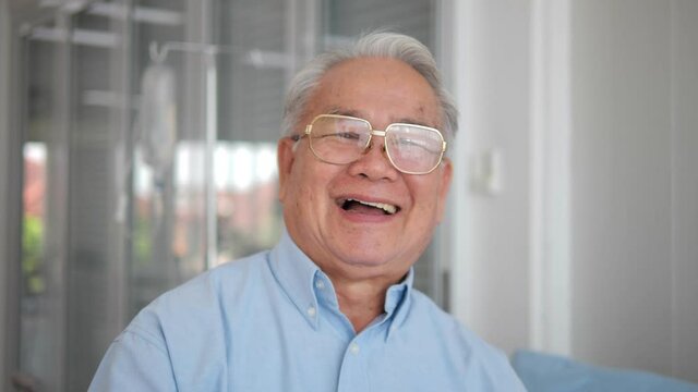 Happy Asian older senior adult man looking at the camera in hospital. healthy cheerful senior patient retired with smiling face portrait.