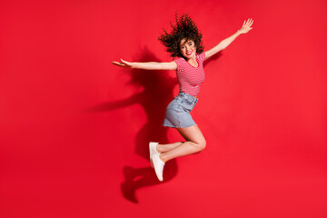 Full body photo of excited happy young girl jump fly wings hands x-mas isolated over red color background