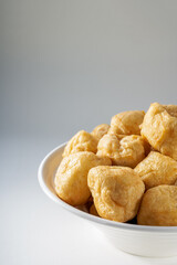 Close-up of a bowl of golden tempting fried tofu with avocado oil