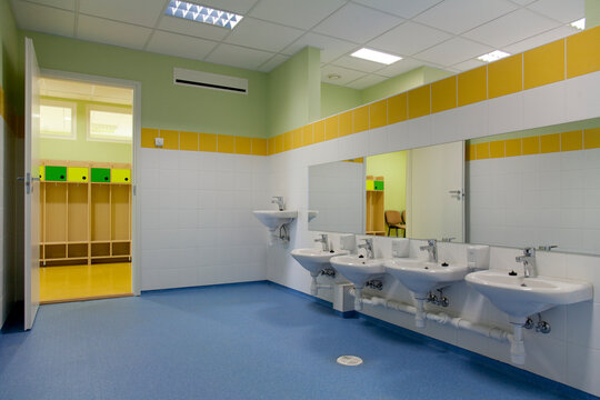 School Restroom, modern style with yellow paint and blue flooring