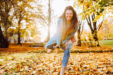 Positive afro hair woman with beautiful smile wearing sky blue laughing in autumn park on sunny day